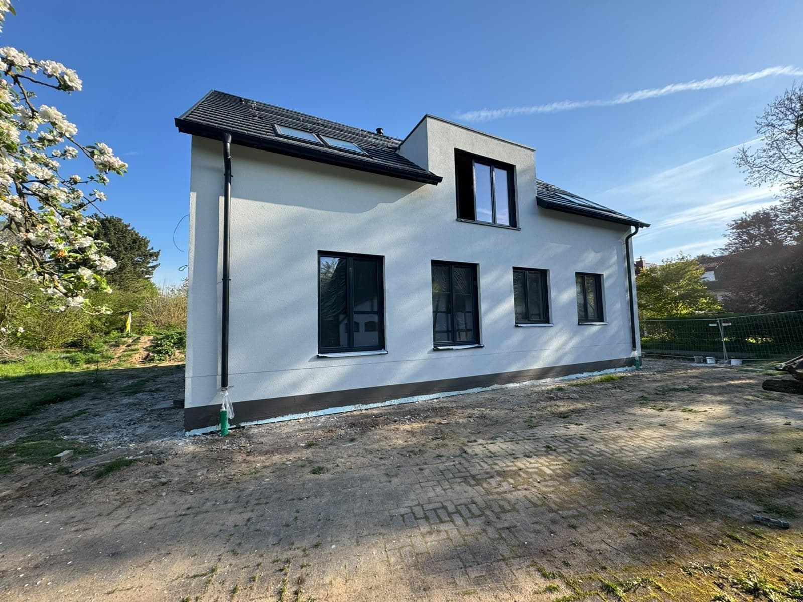 Seitenansicht eines modernisierten Wohnhauses mit heller Fassade