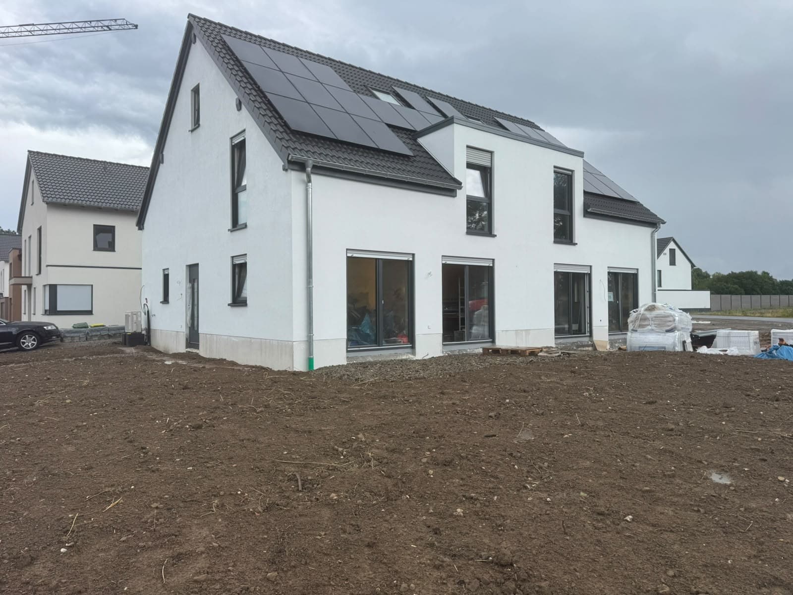 Mehrfamilienhaus mit verputzter Fassade und Solaranlage auf dem Dach